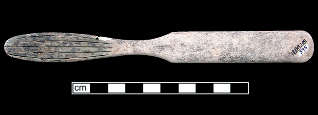 Back view of the bone handled toothbrush showing green copper staining from wire used to hold bristles in place.